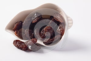 Black currant in a white ceramic cup on a white background