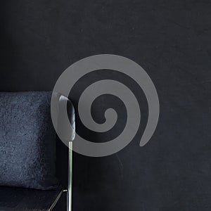 Black cushion on stool in black bedroom interior