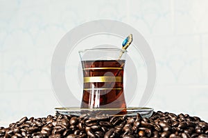 Black delicious coffee in an iron mug, jar and scattered grains on stone table. Authentic drink copy space.