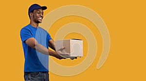 Black delivery man holding cardboard box giving it to side