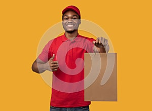Black delivery man holding paper bag showing thumbs up