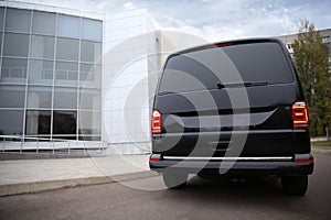 Black delivery van parked on street near building