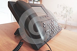 The black desktop push-button telephone. IP phone