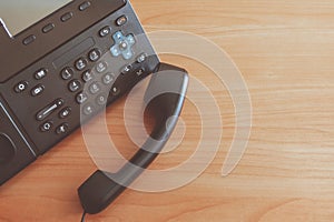 The black desktop push-button telephone. IP phone on desk in office