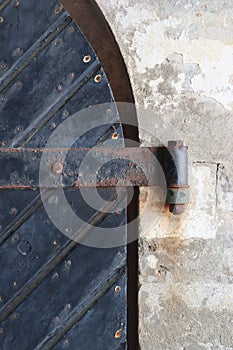 Black diagonal wooden arched door metal hinge on concrete