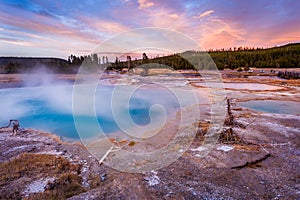 Black Diamond Pool in Biscuit basin with blue steamy water and beautiful colorful sunset. Yellowstone, Wyoming