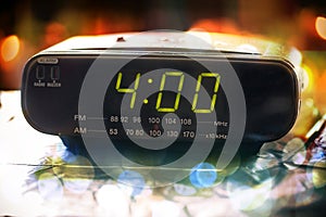 Black digital alarm radio clock.Alarm radio clock indicating time to wake up.Digital clock closeup displaying 4:00 o`clock.Digital