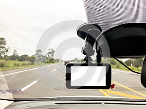 Black digital dashcam camera installed in the car near the rear