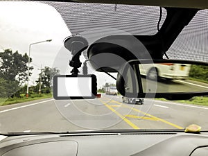 Black digital dashcam camera installed in the car near the rear