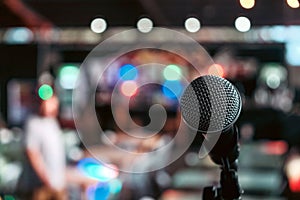 Black directional microphone on a tall stand in the center of a room