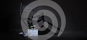 Black director chair and white rainbow Clapper board or movie slate put on floor with megaphone on black background