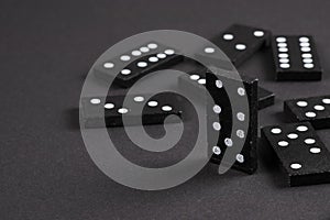 Black Dominoes on dark background, Closeup scattered dominoes on a gray, table. Board game, Game night Dominos table game