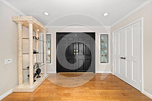 Black door in white entryway with elaborate display cabinet in Encino, CA
