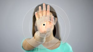 Black dot on womans hand, secret sign of domestic violence victim, support