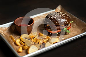 Black double hamburger made from beef, cheese and vegetables.