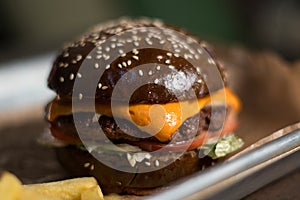 Black double hamburger made from beef, cheese and vegetables.