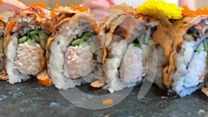 BLACK DRAGON ROLL Crabmeat, Avocado, Kappa Inside with Unagi, Avocado, Fish Flakes and Fish slow motion from the side