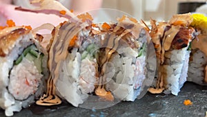 BLACK DRAGON ROLL Crabmeat, Avocado, Kappa Inside with Unagi, Avocado, Fish Flakes and Fish slow motion from the side