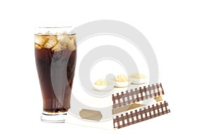 Black drink (cola) and sugar over lettuce over white background