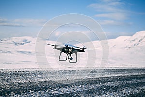 Black drone hoovering above the road