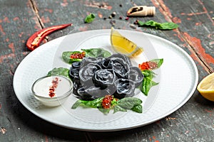 Black dumplings stuffed with fish and caviar. ravioli, dumplings. Russian cuisine. banner, menu, recipe place for text, top view