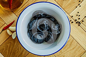 Black dumplings in a white plate on the table.