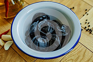 Black dumplings in a white plate on the table.