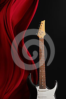 Black electric guitar, red curtain, nobody