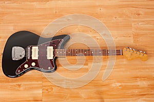 Black electric guitar, studio shoot. Red tortoise shell pickguard, alder body, maple neck, two single coil