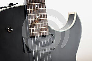 Black electric rock guitar with humbucker pickup close up macro shot