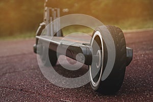 black electric scooter standing on the rubber pad in the park, rear view