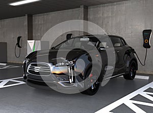 Black electric SUV recharging in parking garage photo