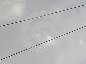 Black electrical cables on sky background