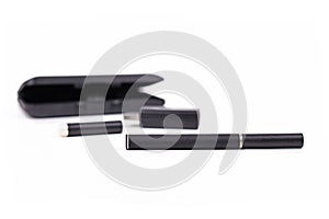 Black electronic cigarette stick with USB charger,  e-liquid cartridge and case in blurry background