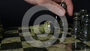 Black elephant in chess defeats white horse. Detail of chess piece on black background. Chess game. closeup view