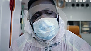 Black emergency service worker taking off face shield