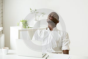 Black employee taking rest doing exercise for relaxation at work photo