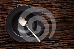 Black empty bowl spoon on wooden table background