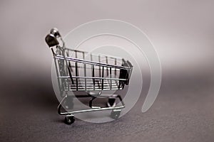 Black empty shopping cart on gray background
