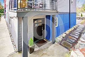 Black entrance door of modernized apartment with natural stone walkway.