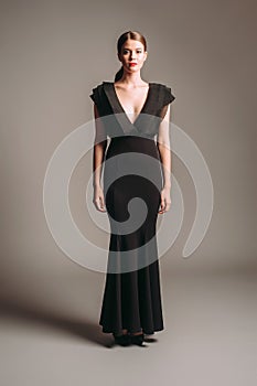 Black evening dress. Elegant lady in full-length sleeveless gown with deep V-neckline