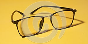 Black eye glasses isolated on yellow background