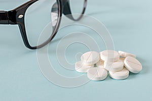 Black Eye Glasses with white pills on blue