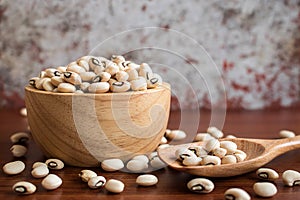 Black eyed beans in wooden bowl on rustic table