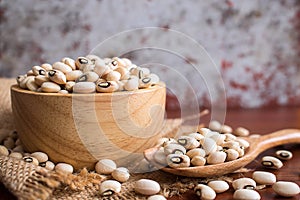 Black eyed beans in wooden bowl on rustic table