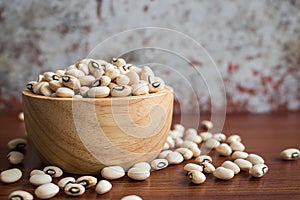 Black eyed beans in wooden bowl on rustic table
