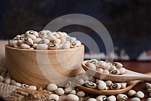 Black eyed beans in wooden bowl on rustic table