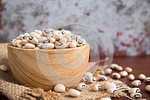 Black eyed beans in wooden bowl on rustic table