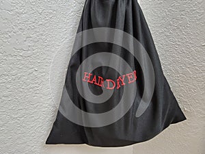 black fabric hair dryer bag on hotel wall with red text