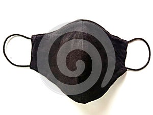 Black face mask cloth wearing to anti virus protection corona COVID-19 isolated on white background closeup.